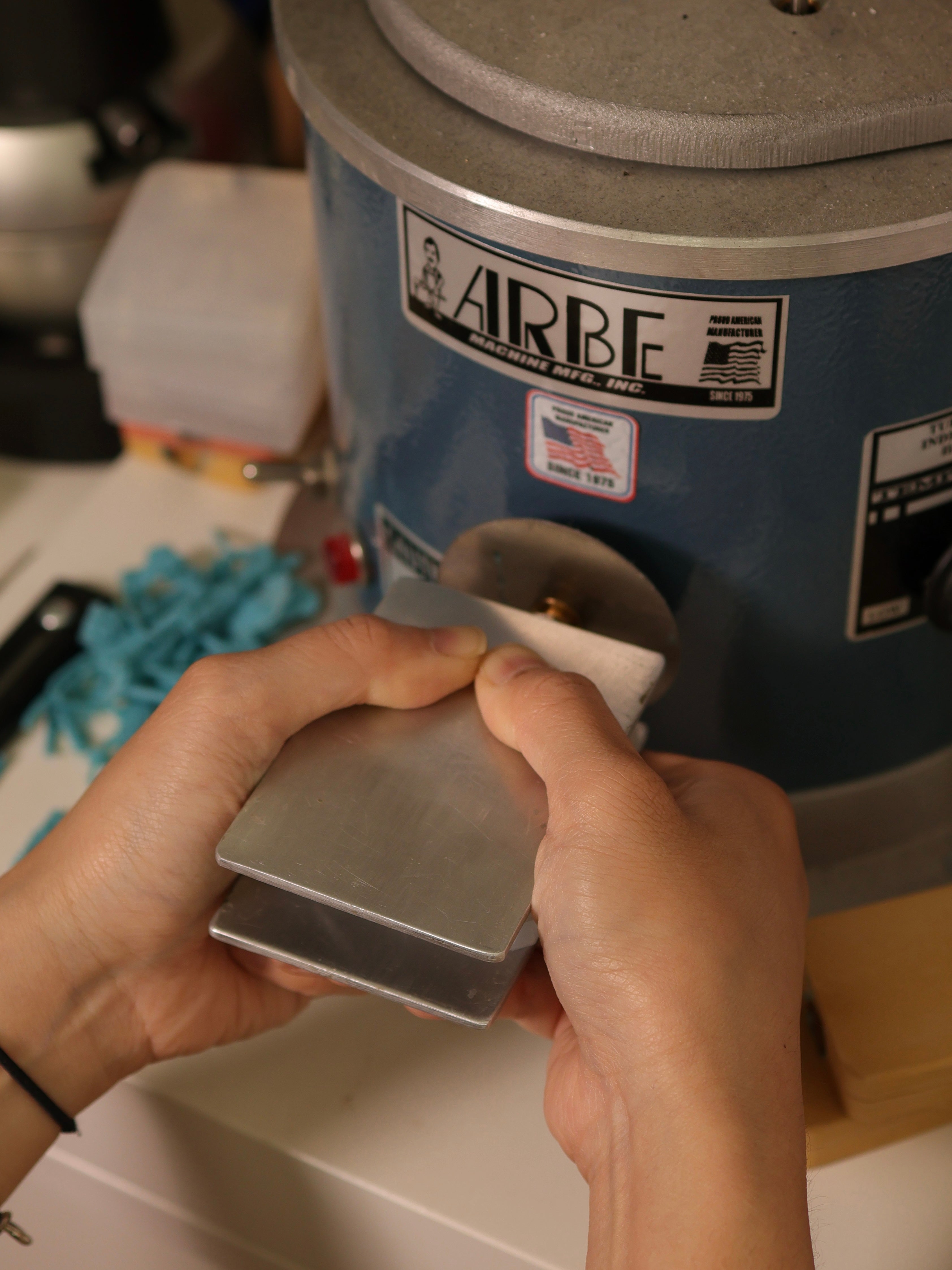 Lilian finishing a poured silver piece at the polishing wheel
