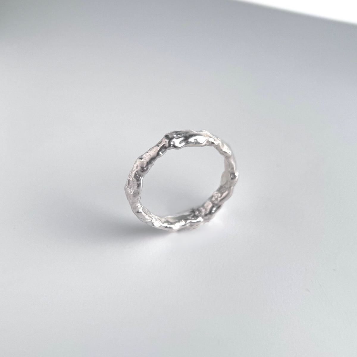 Molten Band Ring, a wide sterling silver band with a rough hand poured molten surface