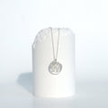 Helix Sentinel Necklace, a round sterling silver pendant with an open helix lattice cut through it